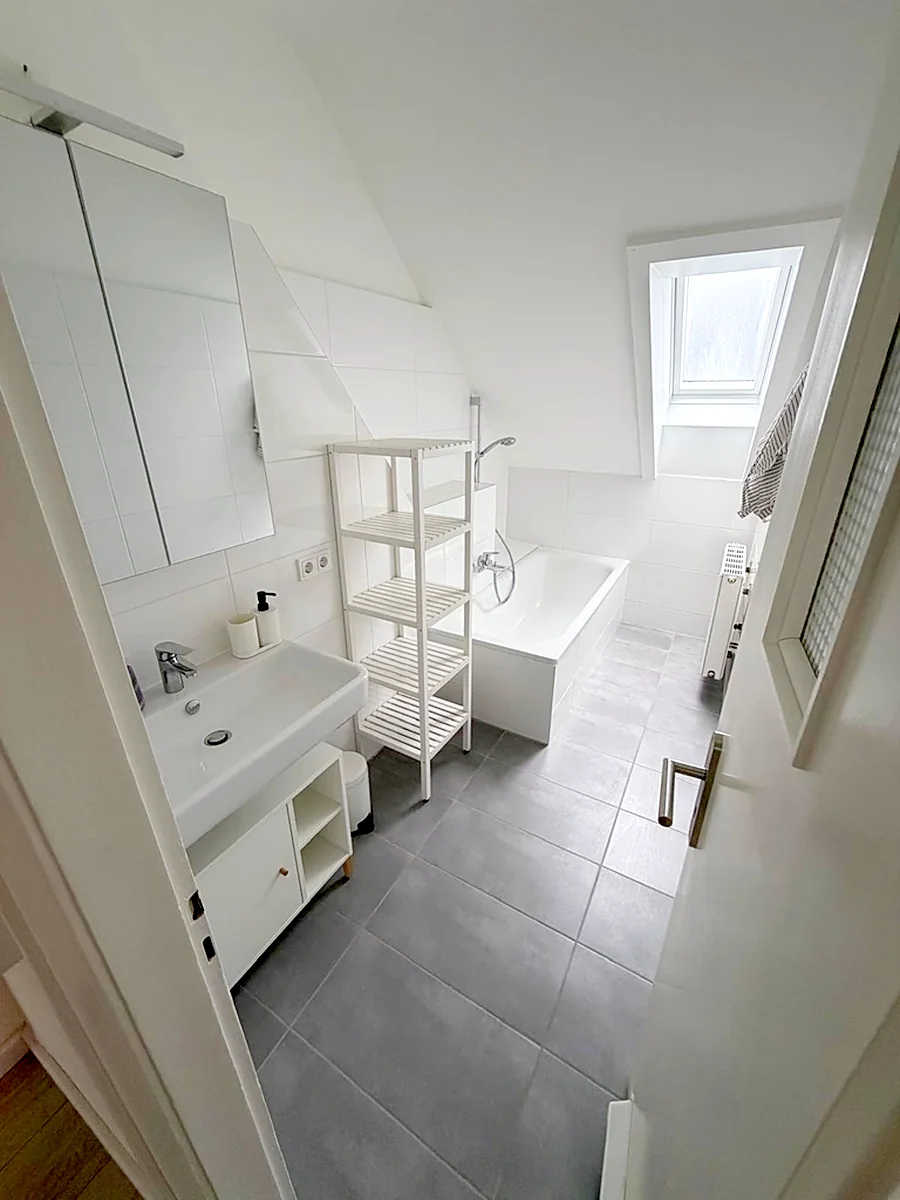 Möbliertes Badezimmer mit Regal und Unterschrank